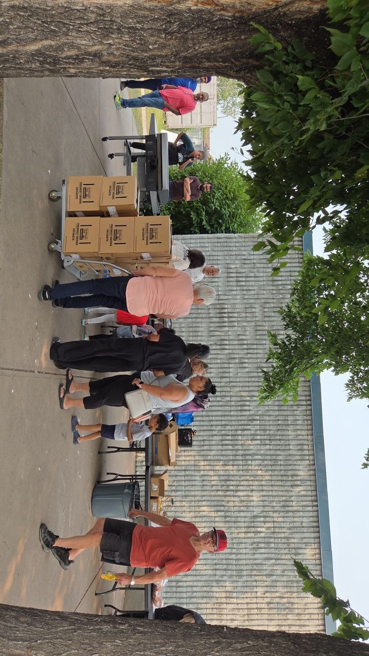 Volunteers and neighbours around boxes of fresh produce at the Pop-Up Pantry