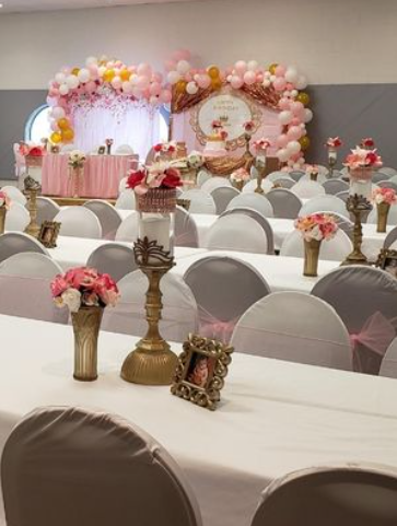 The community hall decorated with balloons and chair covers for a party